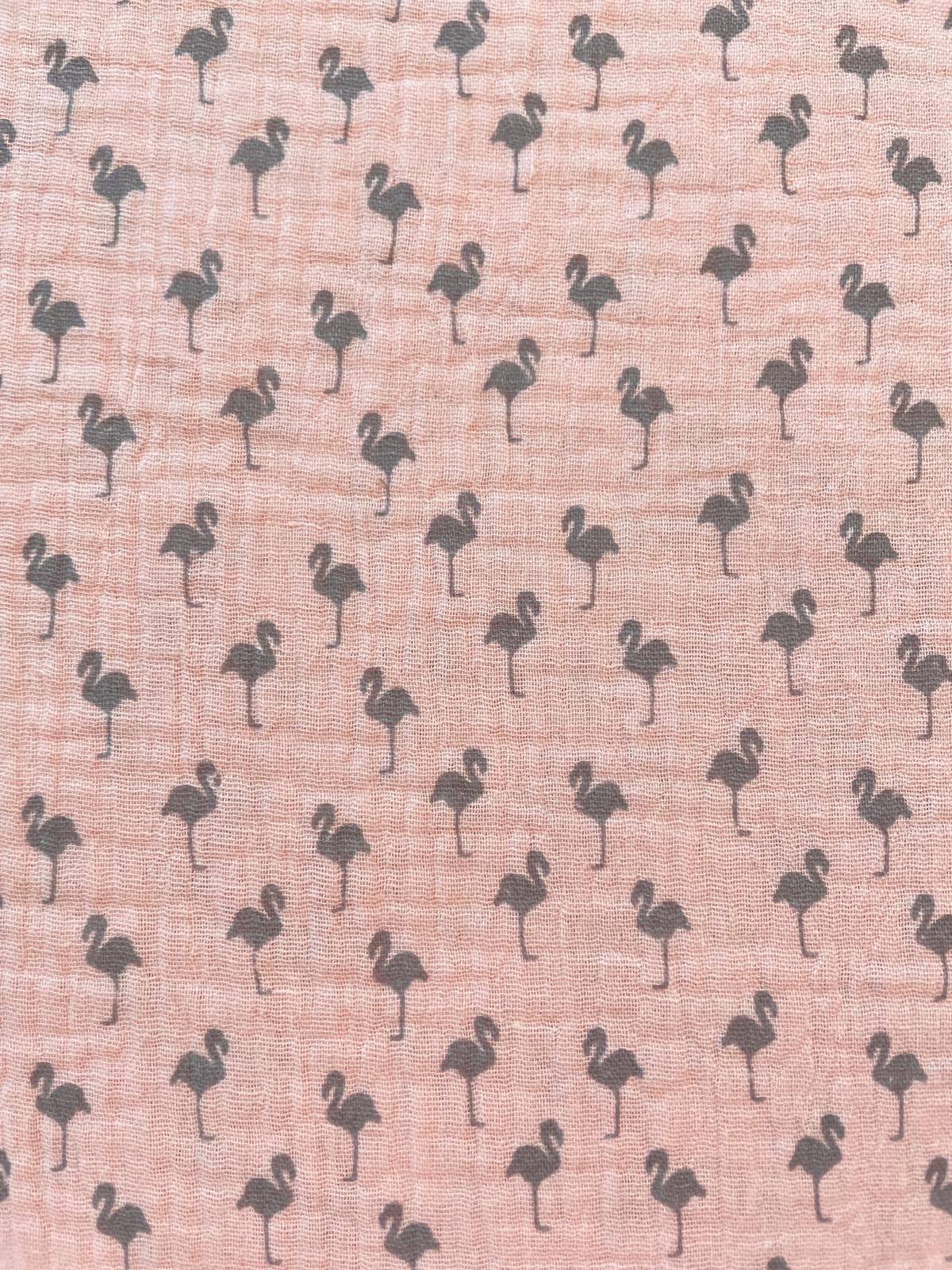 Nahaufnahme von rosa Musselin-Gewebe aus Baumwolle, bedruckt mit kleinen, grauen Flamingo-Silhouetten.