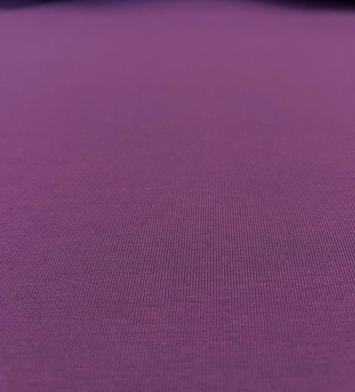 Nahaufnahme eines elastischen Baumwoll-Jerseystoffs in kräftigem Violett/Beere mit feiner Maschenstruktur.