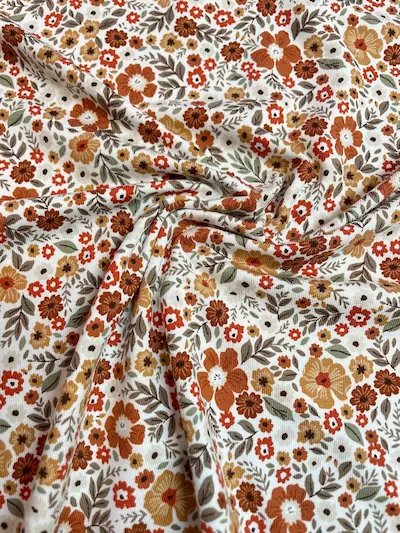 Hochwertiger Jerseystoff mit dichtem floralem Retro-Muster in warmen Erdtönen wie Rost und Ocker, elastische Baumwoll-Meterware für Vintage-Liebhaber.
