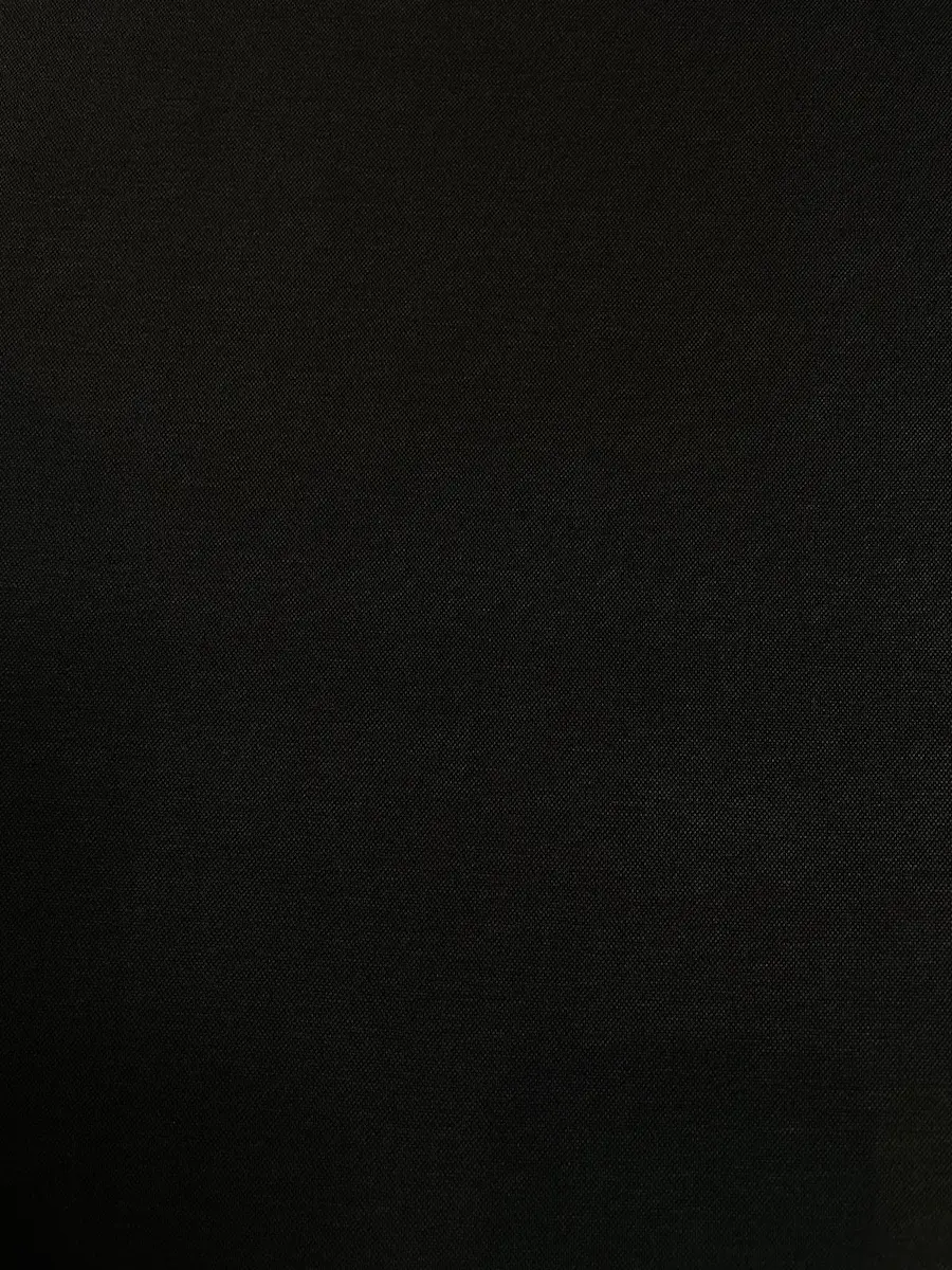 Blick auf die feine Oberflächenstruktur eines tiefschwarzen Interlock-Jerseystoffs. Blickdicht, elastisch und beidseitig glatt gestrickt.
