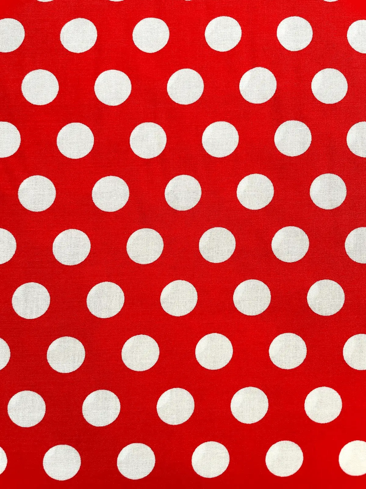 Nahaufnahme von Viskose Webware Meterware in Rot mit gleichmäßigen weißen Punkten (Polka Dots).
