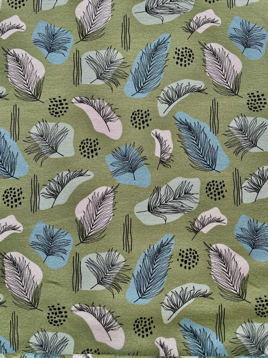 Olivgrüner French Terry Stoff mit einem modernen Print aus abstrakten Blättern und Federn in den Farben Blau, Rosa und Schwarz.