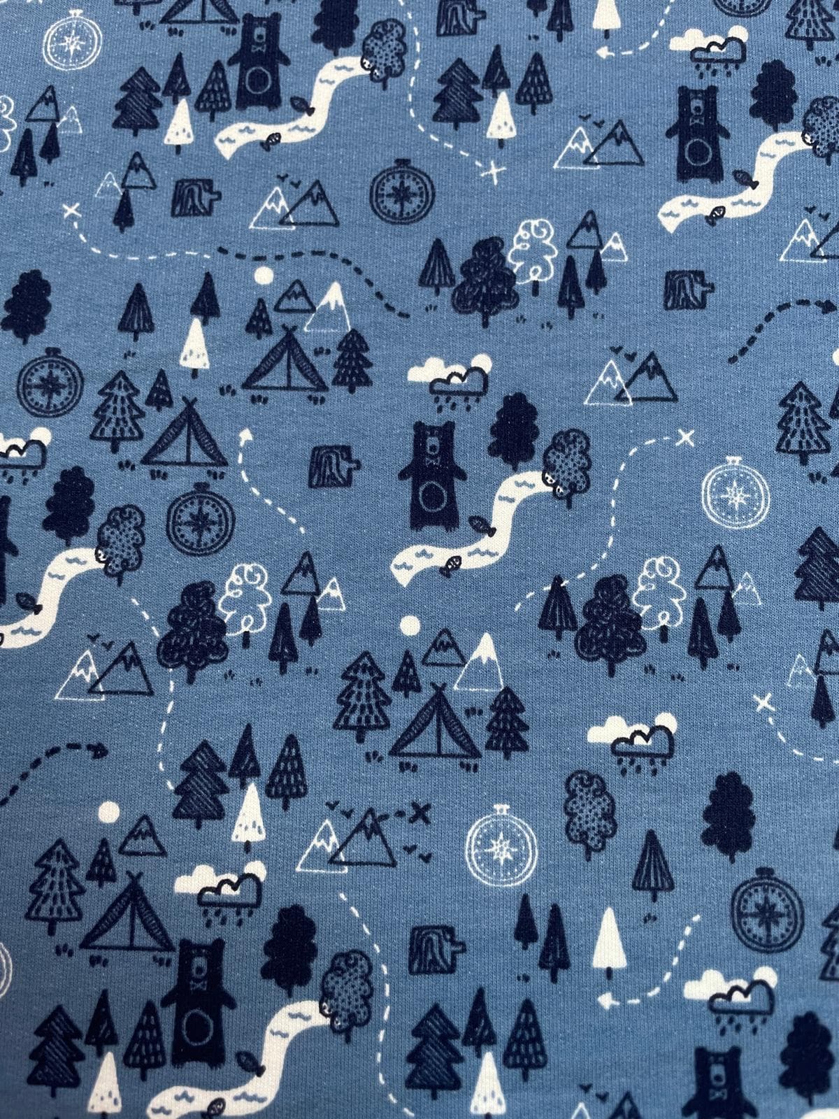 Leicht angerauter Sweatstoff in Jeansblau meliert mit Bären, Bergen und Camping-Motiven, weicher Sommersweat für Kinderpullover Meterware.