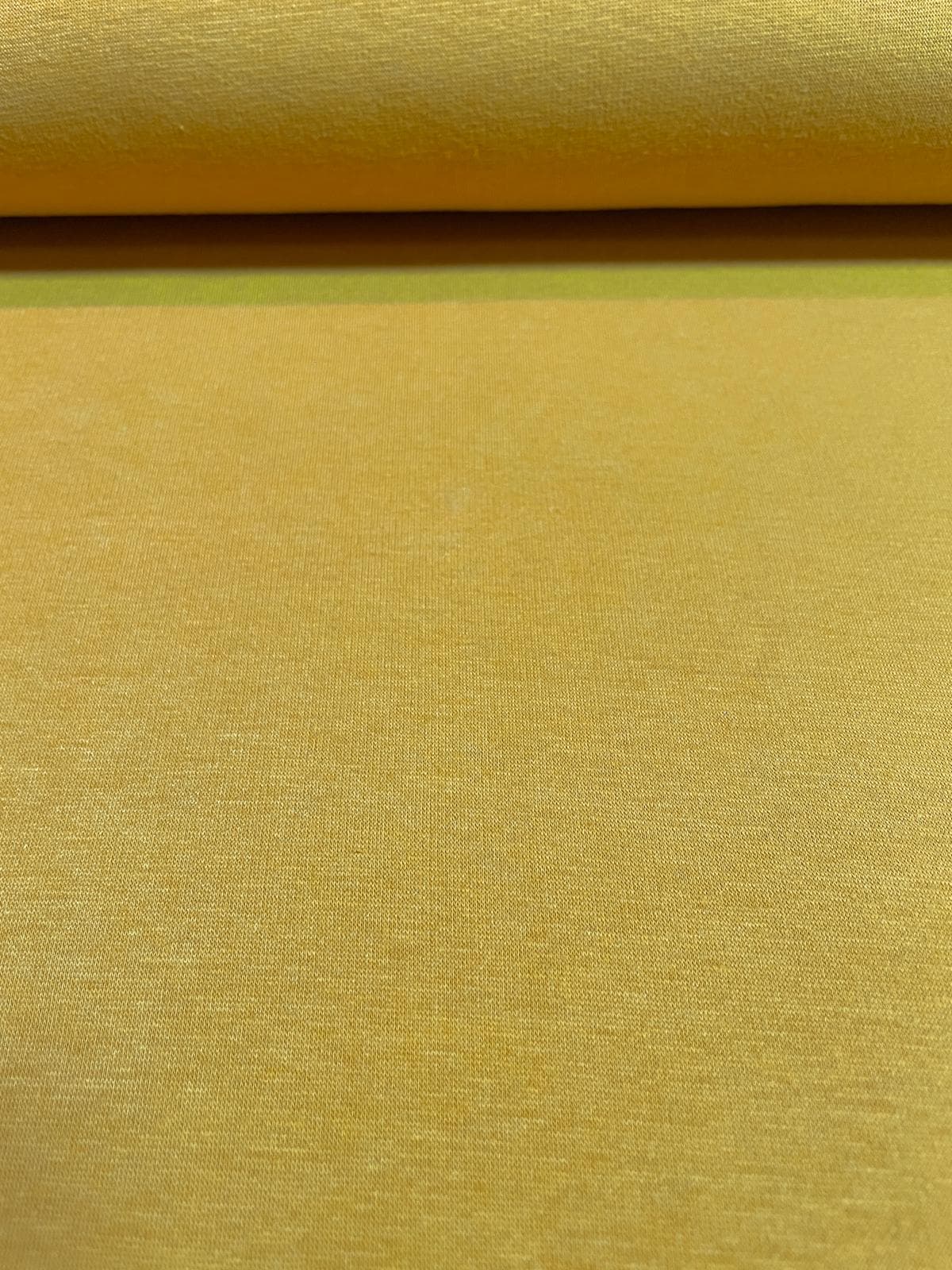 Nahaufnahme von Alpenfleece-Stoff als Meterware in der Farbe Senfgelb mit feiner Oberflächenstruktur