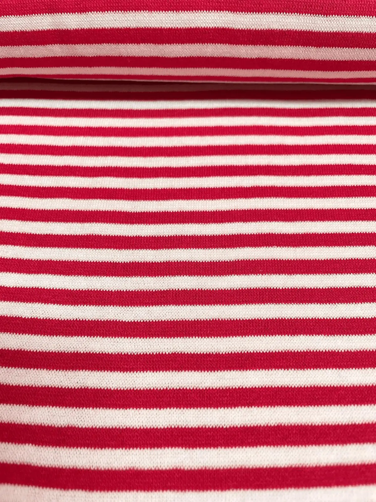 Gestreifter Bündchenstoff in Rot und Weiß als elastische Schlauchware (Meterware) für Pulloverbündchen und Kindermode.
