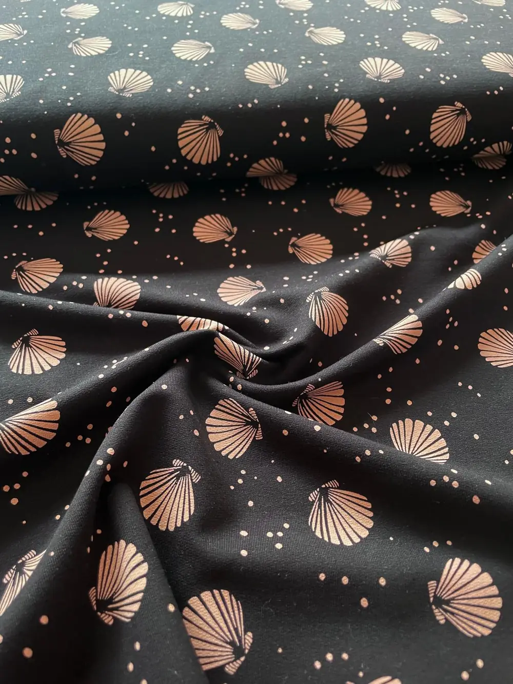 Hochwertiger French Terry Stoff als Meterware in Schwarz mit elegantem, goldfarbenem Muschel-Muster und Pünktchen, ideal für Bekleidung