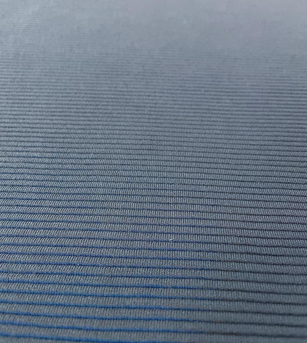 Nahaufnahme von Jersey Ottoman Stoff in Taubenblau mit ausgeprägter horizontaler Rippenstruktur.