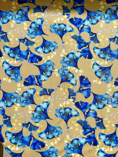 Nachhaltige Eco-Viskose Webware als Meterware mit Ginkgo-Blattmuster in Blau und Gelb auf senffarbenem Grund