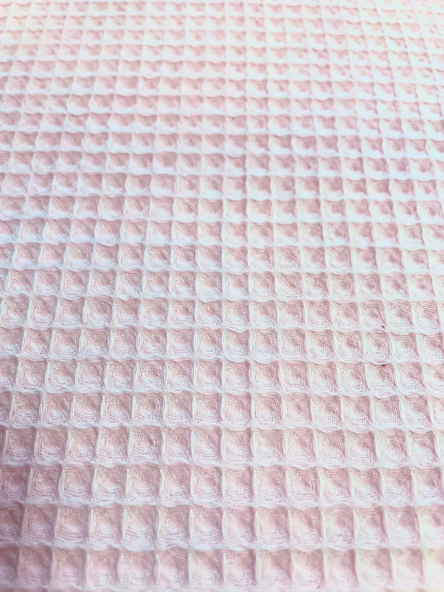Nahaufnahme von rosafarbenem Waffelpique Stoff als Meterware mit klassischer Waffelstruktur für Babydecken, Handtücher und Accessoires.