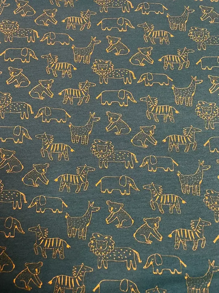 Dunkelgrüner Sweatstoff als Meterware mit orangefarbenen Konturen von Safari-Tieren wie Löwe, Zebra und Elefant, ideal für Kinderkleidung.