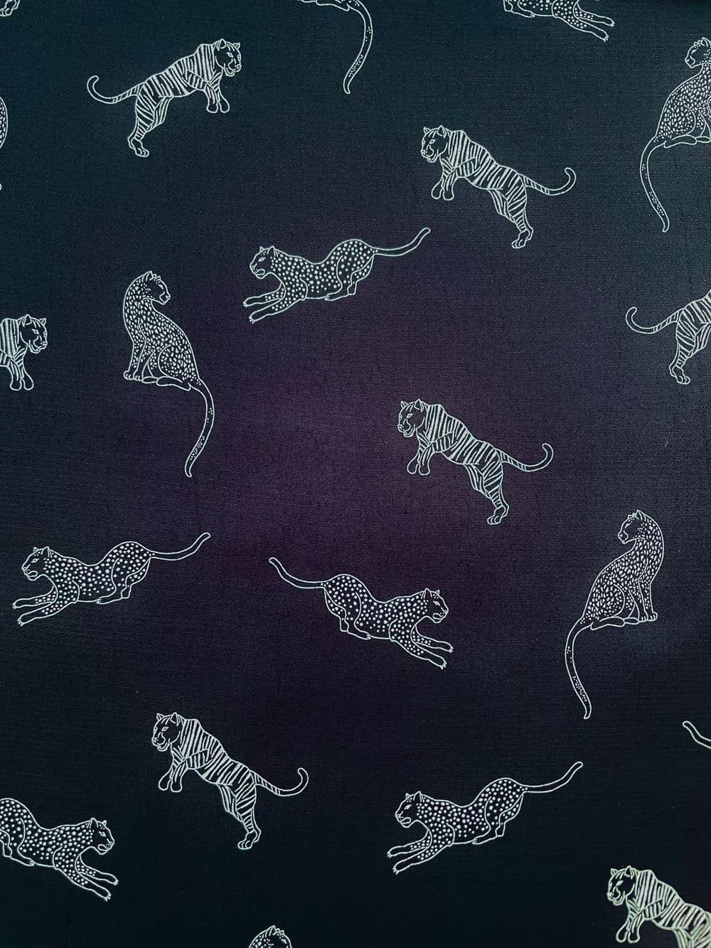 Dunkelblauer, fließender Viskosestoff (100% Viskose) mit filigranen, weißen Linienzeichnungen von Tigern und Leoparden in verschiedenen Posen.