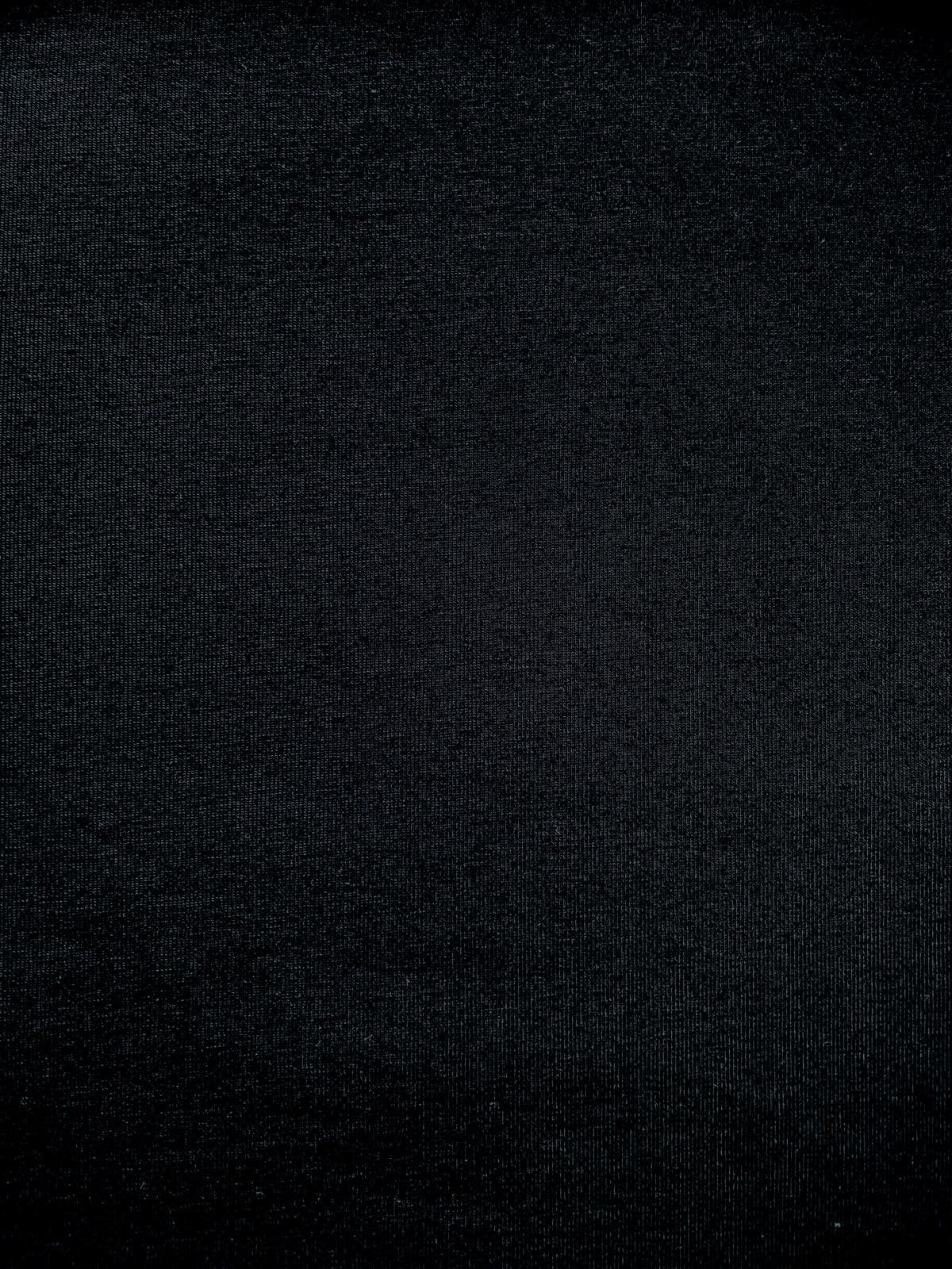 Nahaufnahme von elastischem Baumwolljersey Stoff in Uni Schwarz mit feiner Strickstruktur.