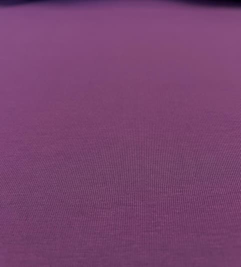 Nahaufnahme eines elastischen Baumwoll-Jerseystoffs in kräftigem Violett/Beere mit feiner Maschenstruktur.