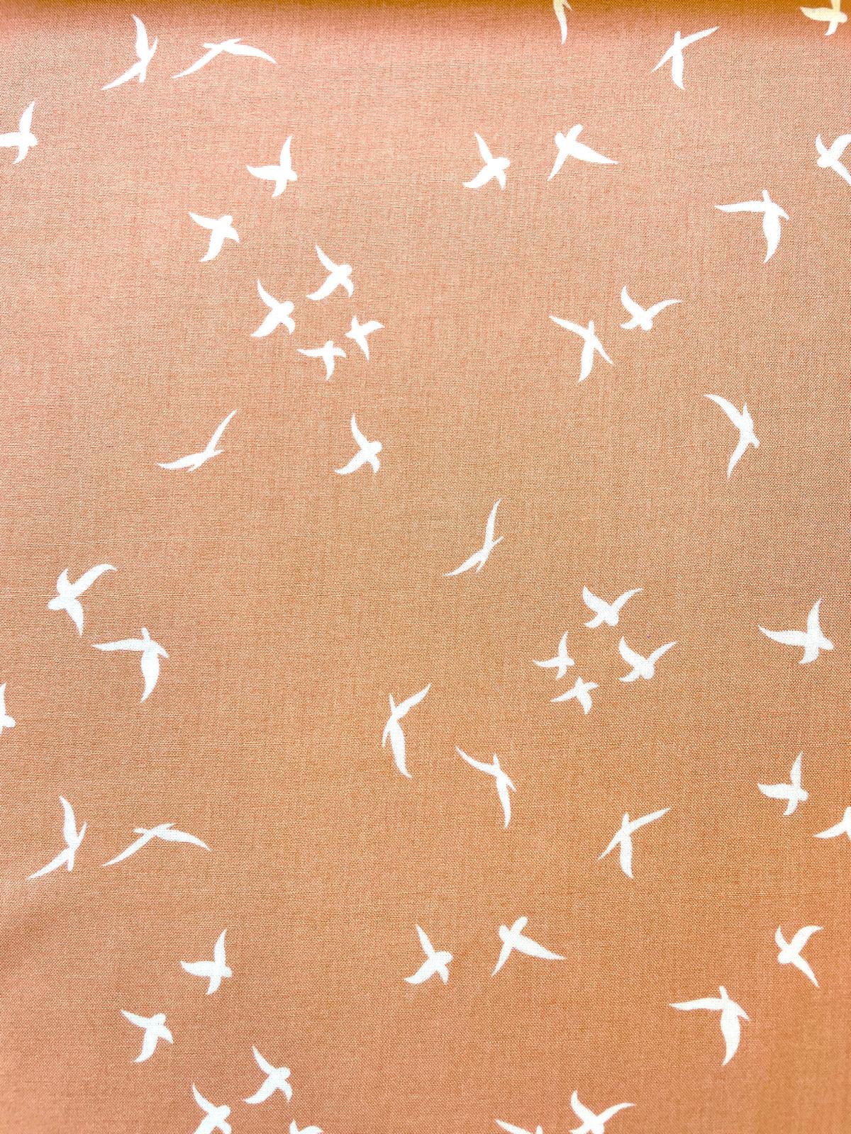 Terrakottafarbener Viskose-Webstoff mit kleinen weißen Vögeln, 140cm breit, Meterware für Bekleidung.