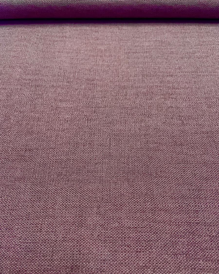Nahaufnahme eines melierten Dekostoffs in gedecktem Mauve-Lila mit feiner Webstruktur aus Baumwolle und Polyester.
