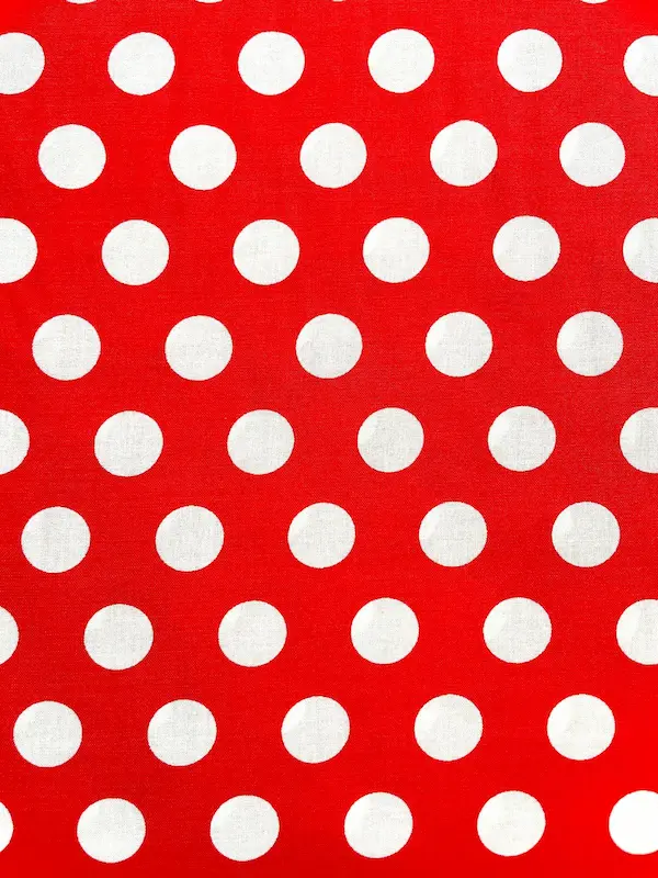 Nahaufnahme von Viskose Webware Meterware in Rot mit gleichmäßigen weißen Punkten (Polka Dots).