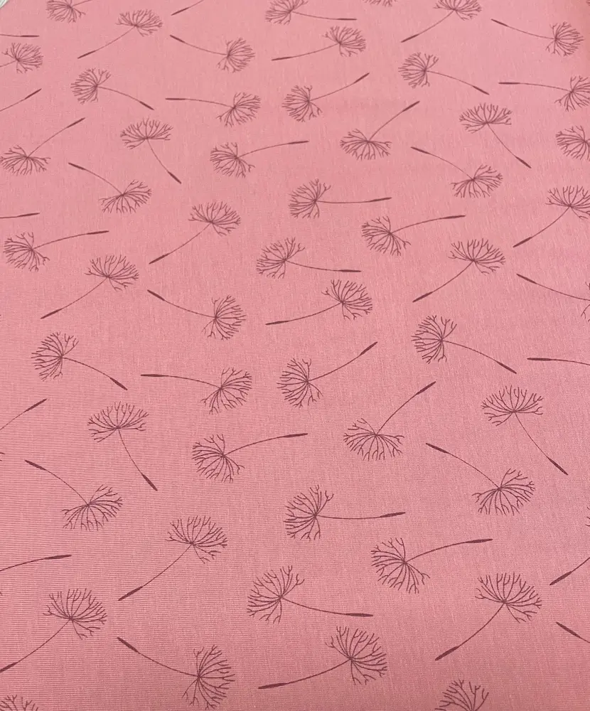Hochwertiger Baumwolljersey Stoff als Meterware in Altrosa, bedruckt mit einem filigranen Pusteblumen-Muster in Dunkelrosa.