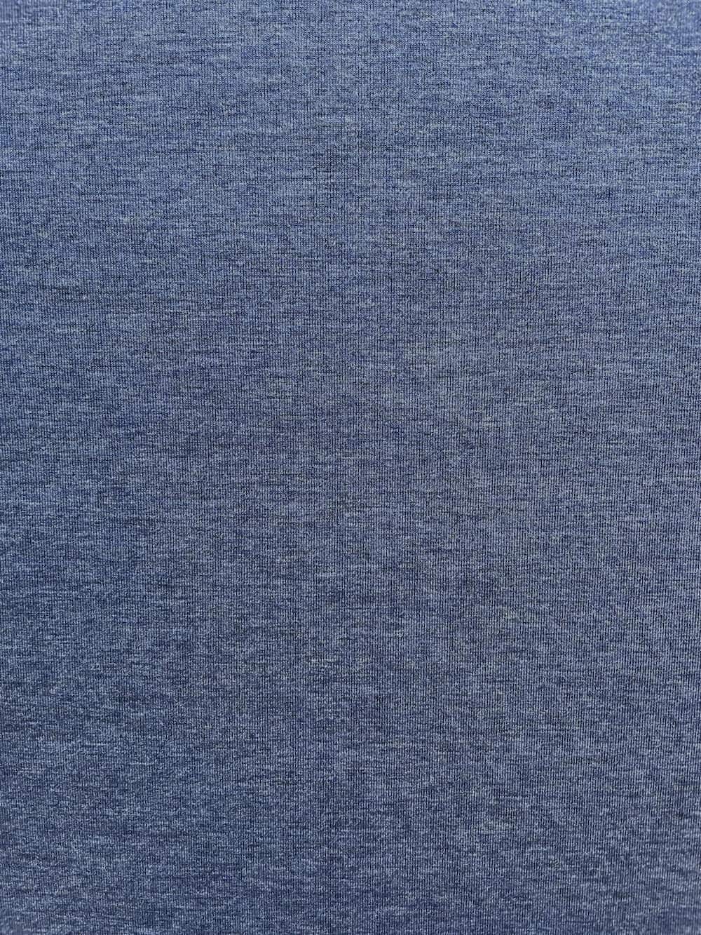 Nahaufnahme von elastischem Jersey-Stoff in Jeans-Blau Melange Optik, feine Strickstruktur aus Baumwolle und Polyester.