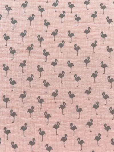 Nahaufnahme von rosa Musselin-Gewebe aus Baumwolle, bedruckt mit kleinen, grauen Flamingo-Silhouetten.