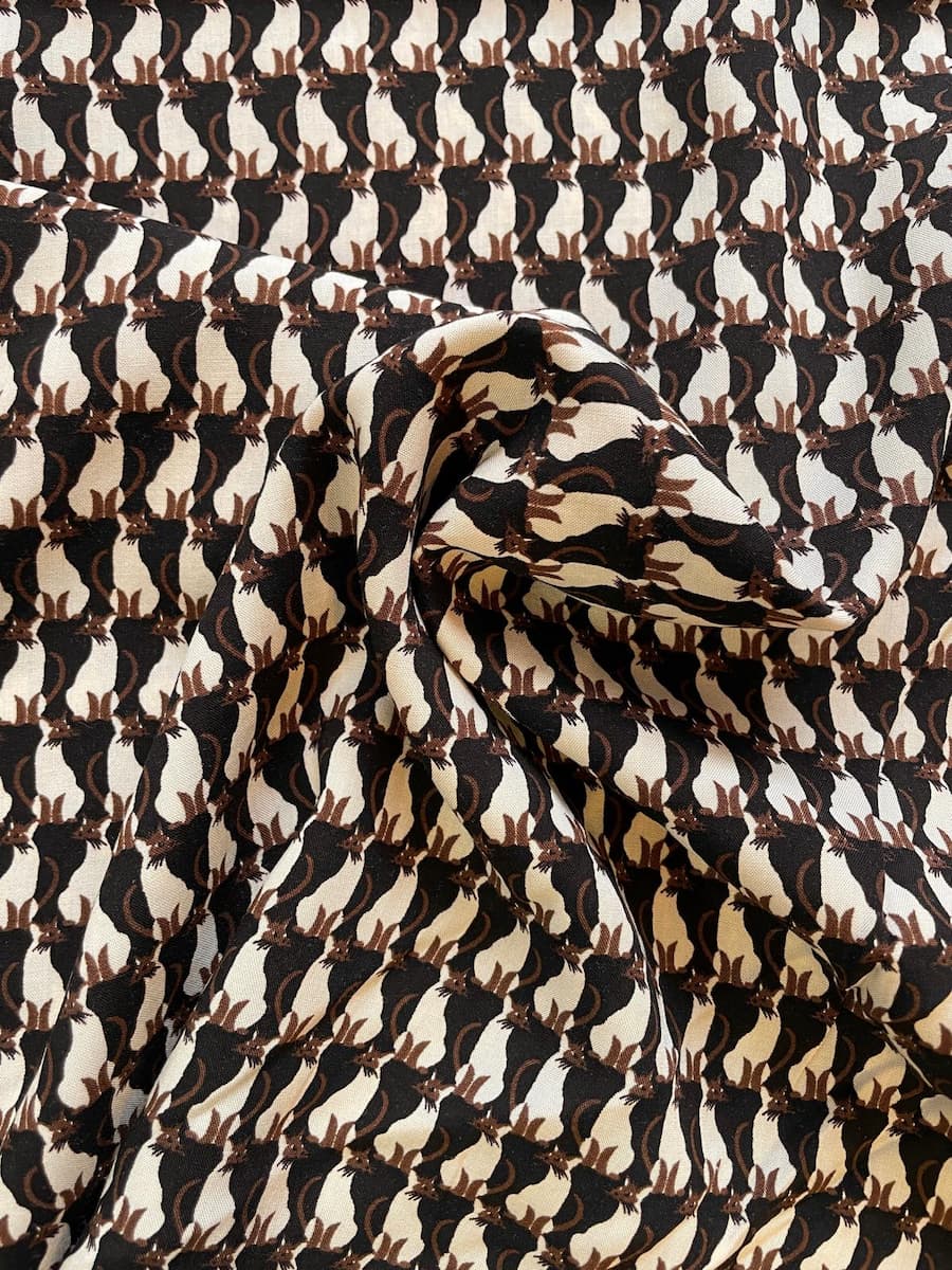 Fließender Viskosestoff mit grafischem Katzenmuster in Schwarz und Creme, 100% Viskose Webware für Kleider und Blusen.