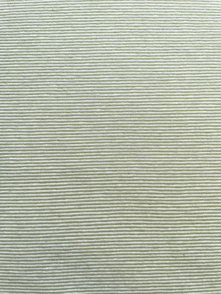 Nahaufnahme von weichem Baumwolljersey in Salbeigrün mit feinen weißen Querstreifen, ideal als Meterware für moderne Baby- und Kinderkleidung.