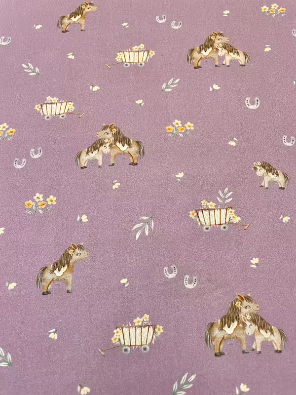 Hochwertiger Baumwollstoff in Mauve mit verspieltem Pony-Print, Hufeisen und Blumenwagen für Kinderbettwäsche und Accessoires.