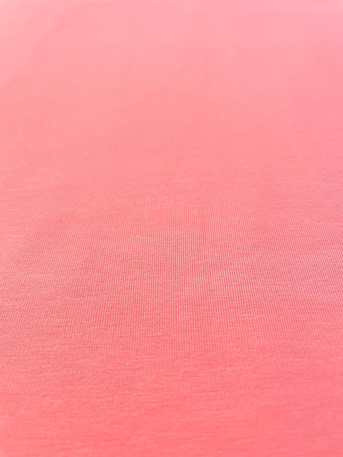 Nahaufnahme eines lachsfarbenen Baumwolljerseys mit feiner Maschenstruktur, 159 cm breit, ideal für Kinderkleidung und Damenmode.