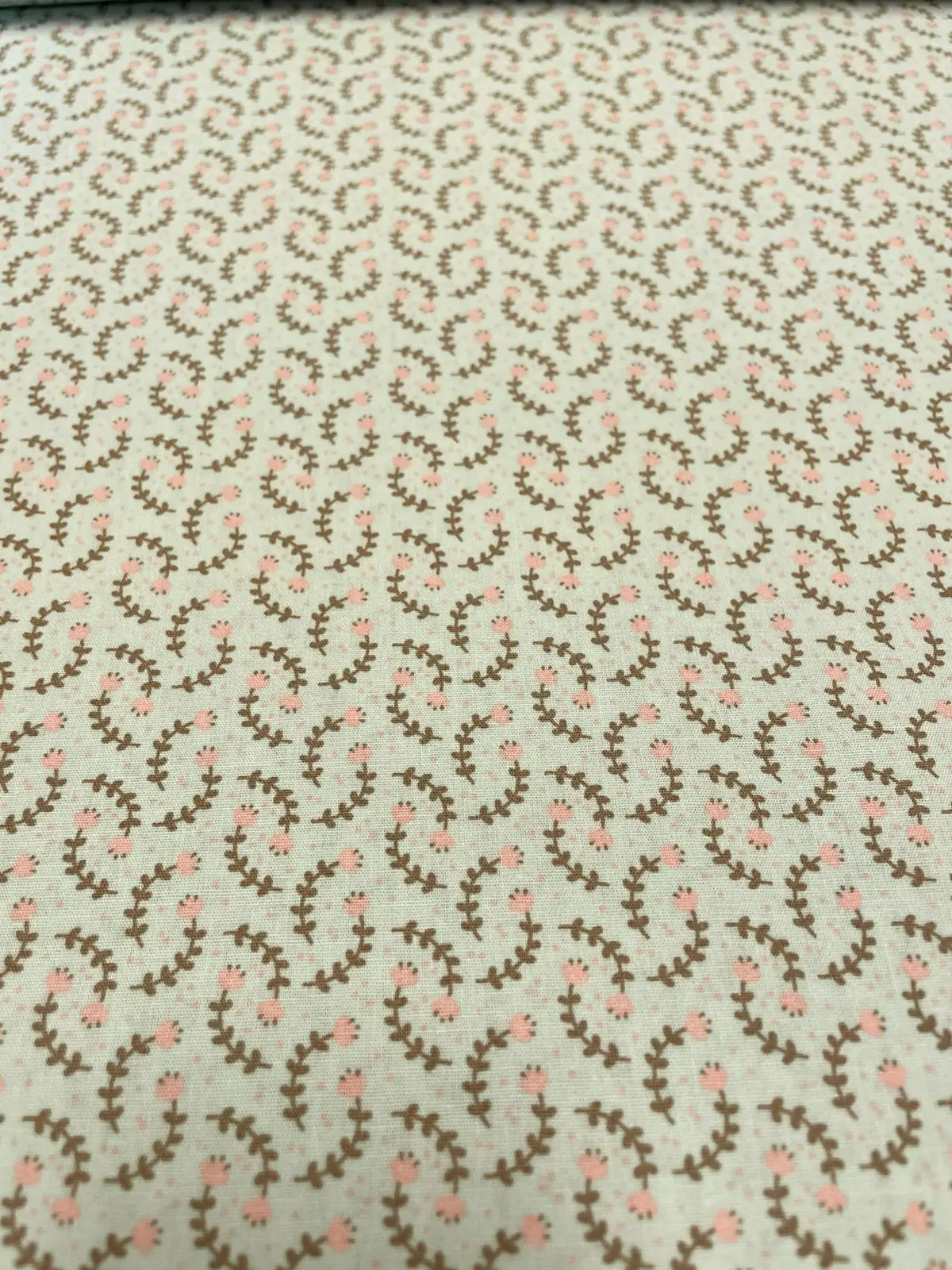 Hochwertiger Baumwollstoff als Meterware in hellem Mintgrün mit einem feinen, botanischen Muster aus zarten Zweigen und Blättern.
