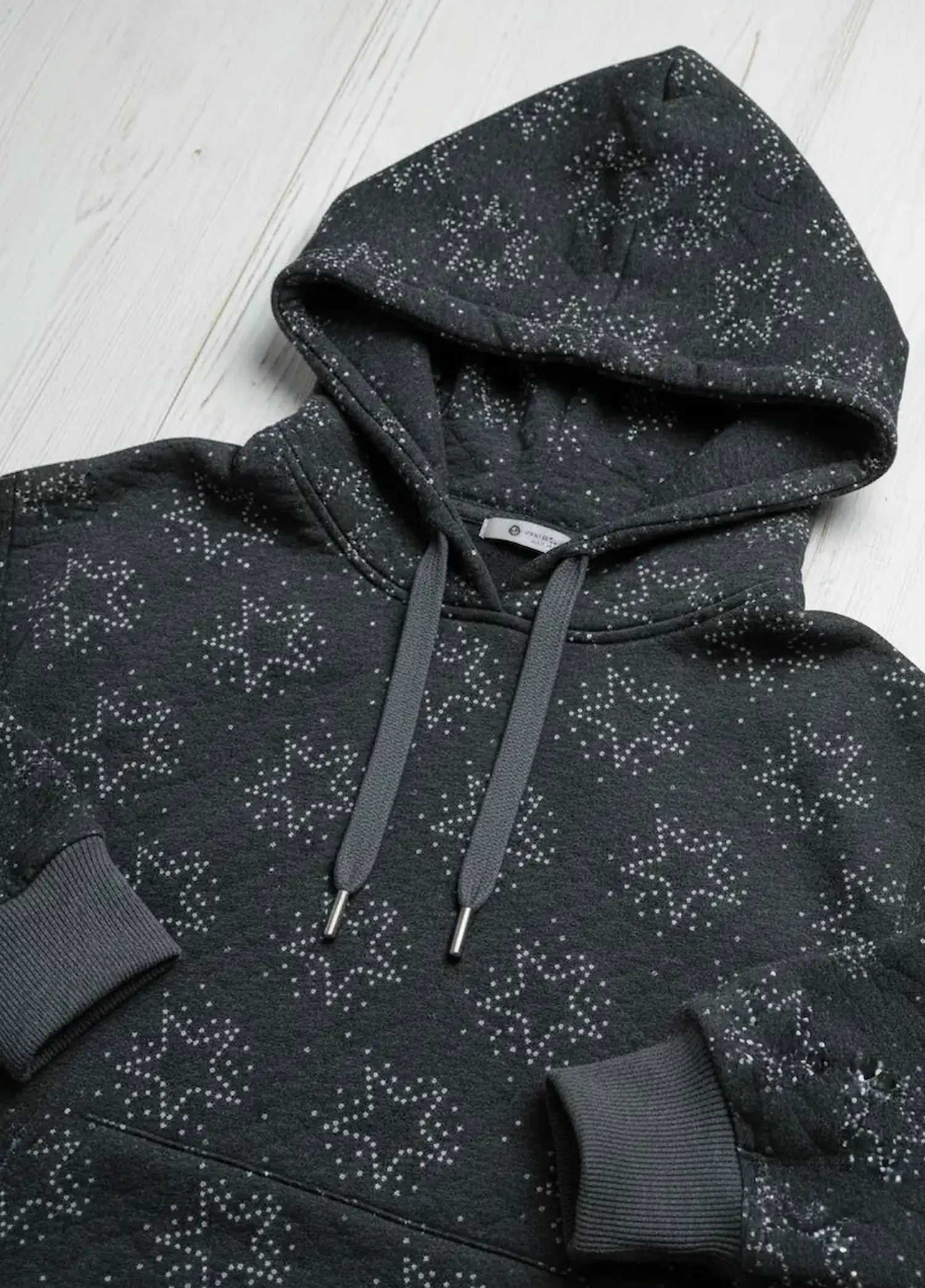 Selbstgenähter, dunkelgrauer Hoodie aus Sweat-Steppstoff mit Sternenmuster, Kapuze, grauen Kordeln mit Metallenden und farblich passenden Rippbündchen.