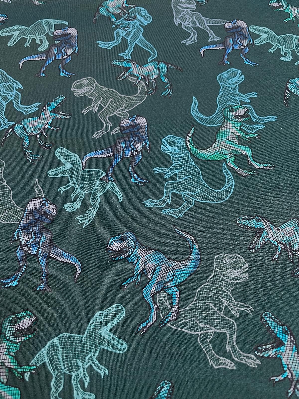 Hochwertiger French Terry Sommersweat in dunklem Petrol. Das Muster zeigt verschiedene Dinosaurier (T-Rex) in einer modernen Gitter-Optik (Wireframe) sowie ausgefüllte Dinos in leuchtendem Türkis, Blau und Weiß. Ein elastischer Baumwolljersey, ideal für J