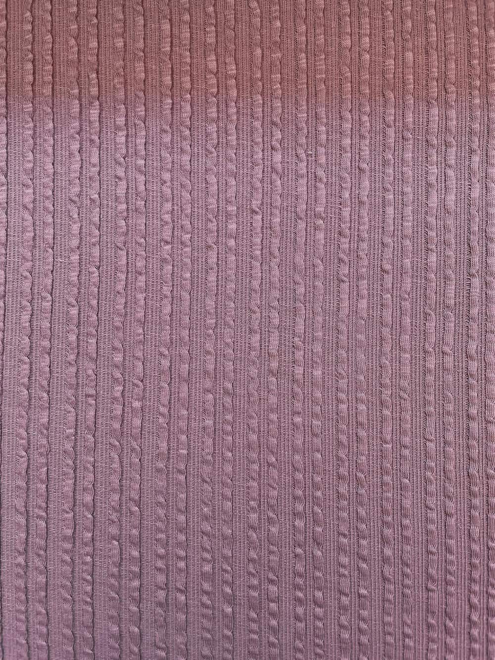 Hochwertiger Baumwolljersey in Mauve mit vertikaler Zopfstrick-Struktur, weiche Haptik für Kinderkleidung und Accessoires.