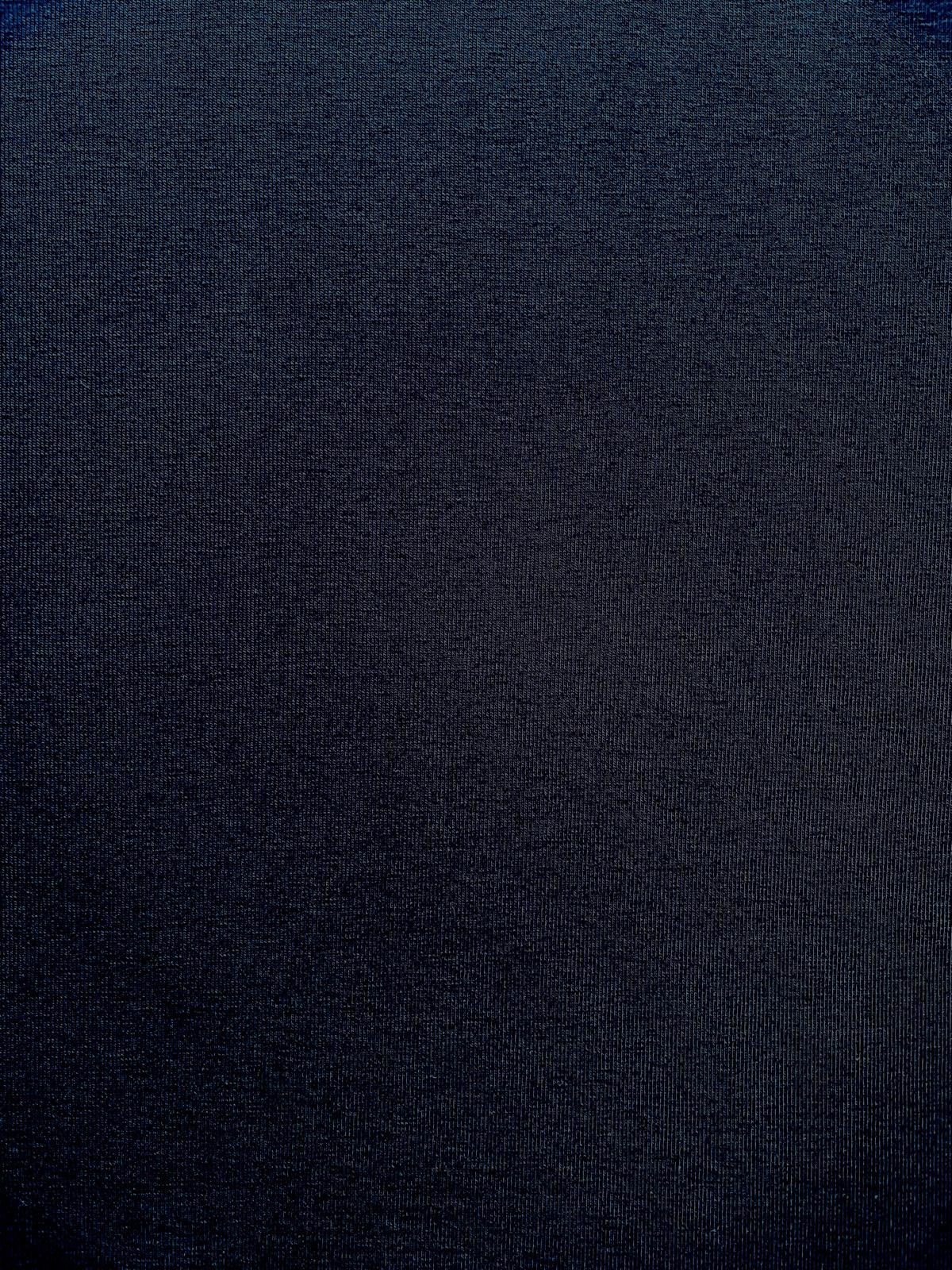 Nahaufnahme eines fein gestrickten, dunkelblauen Jersey-Stoffs aus Baumwolle mit dezenter Textur für hochwertige Bekleidung.
