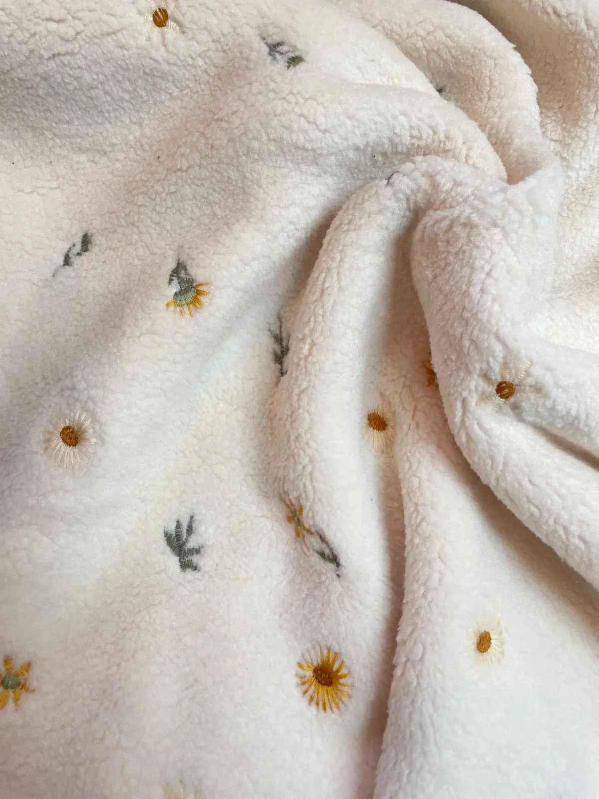Flauschiger Teddy-Plüsch Stoff in Creme mit filigraner Blumen-Bestickung, kleine Gänseblümchen in Gelb und Weiß auf weichem Borg-Gewebe