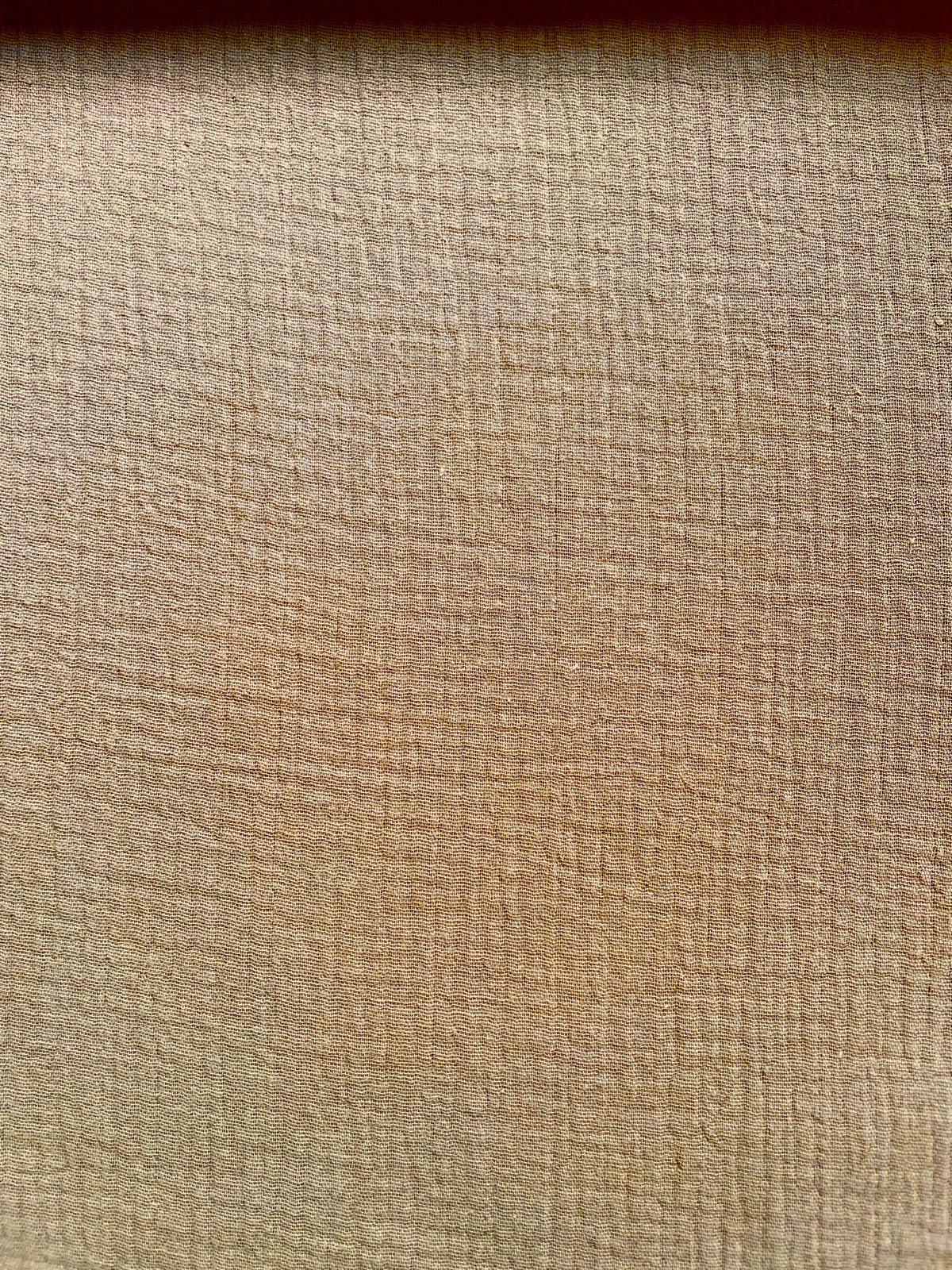Struktur von warm-beigem Musselin-Stoff aus 100% Baumwolle, 130g/m² Gewicht und 140cm Breite für Näharbeiten.