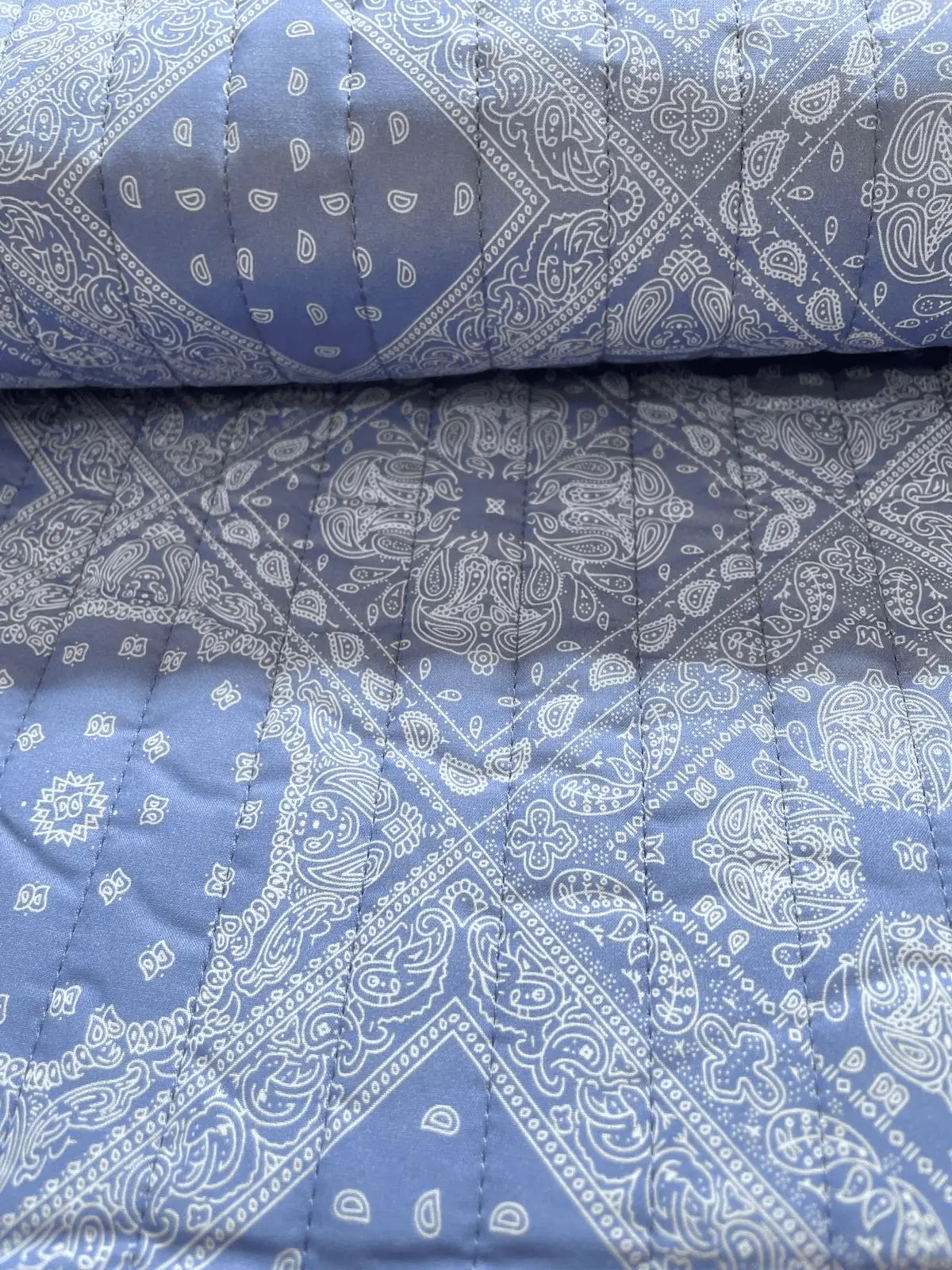 Hochwertiger, beidseitig verwendbarer Steppstoff als Meterware mit elegantem blauem Paisley-Muster, perfekt geeignet für wendbare Jacken und Wohnaccessoires.