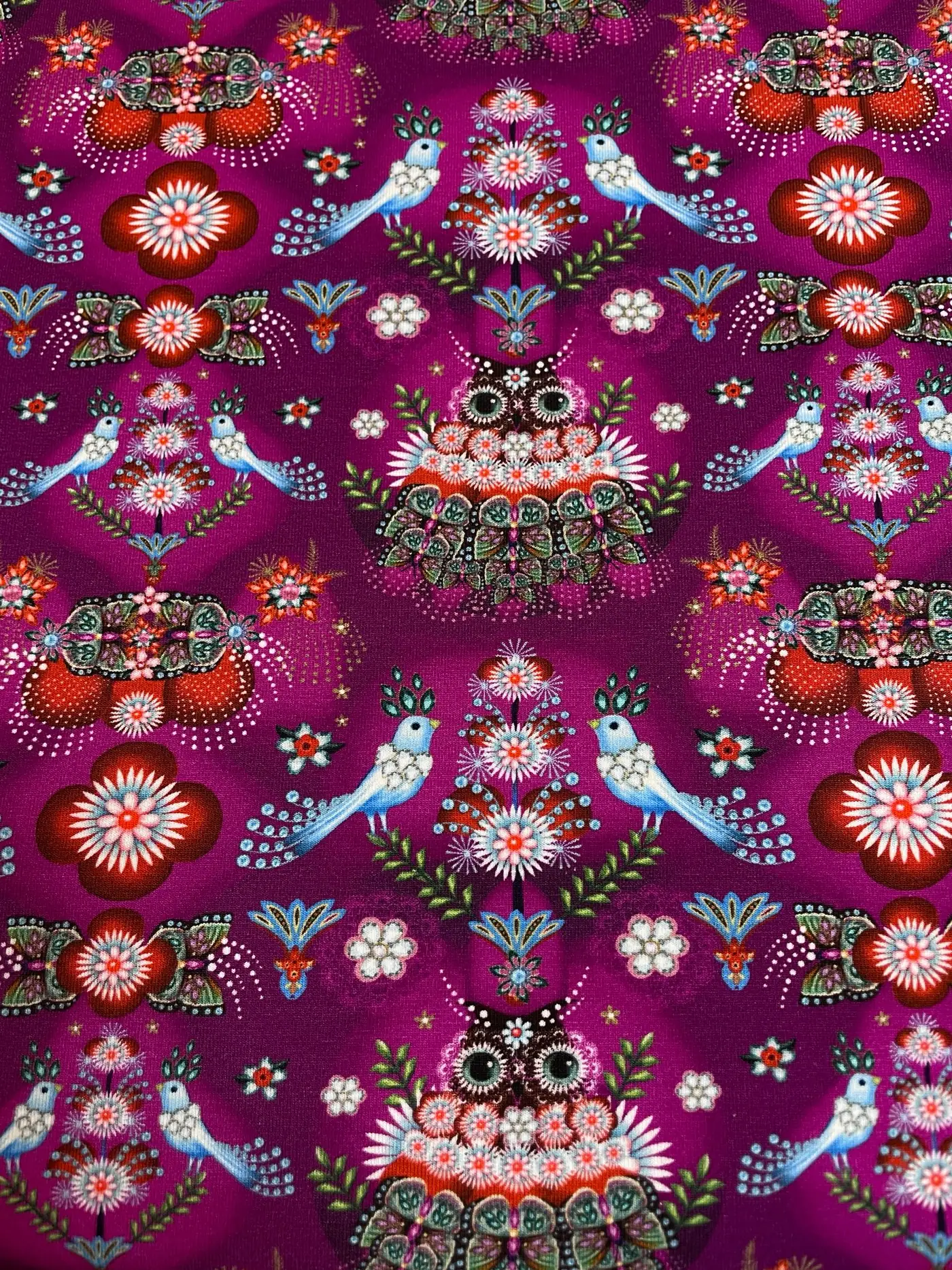Detailreicher Baumwolljersey mit Folklore-Print: Symmetrische Eulen- und Vogelmotive auf leuchtendem Magenta. Hochwertiger Digitaldruck für Kleidung und Accessoires.