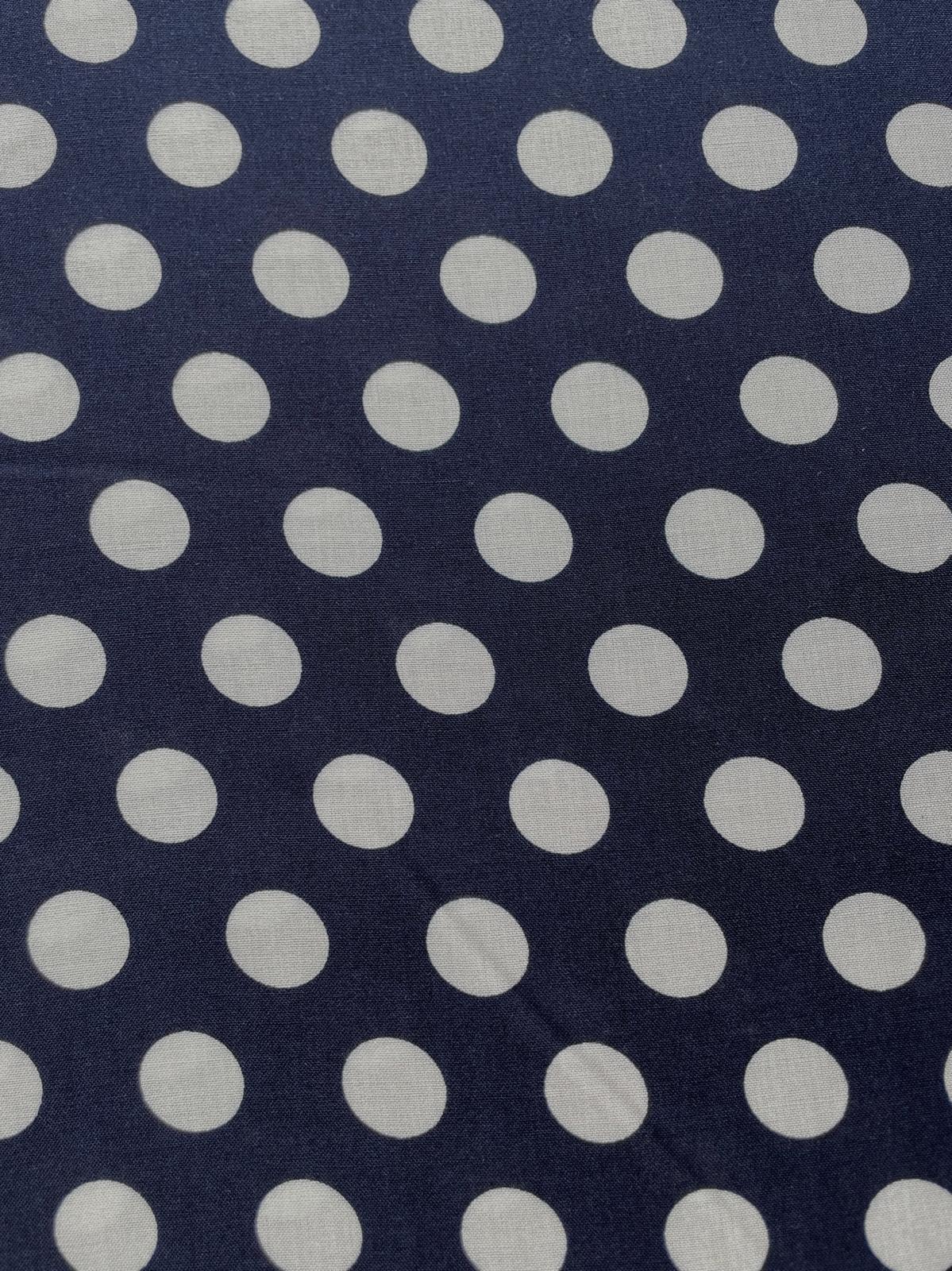 Nahaufnahme eines fließenden, dunkelblauen Viskosestoffs mit einem regelmäßigen Muster aus großen, hellbeigen Polka Dots. Die Stoffbreite beträgt 142cm.