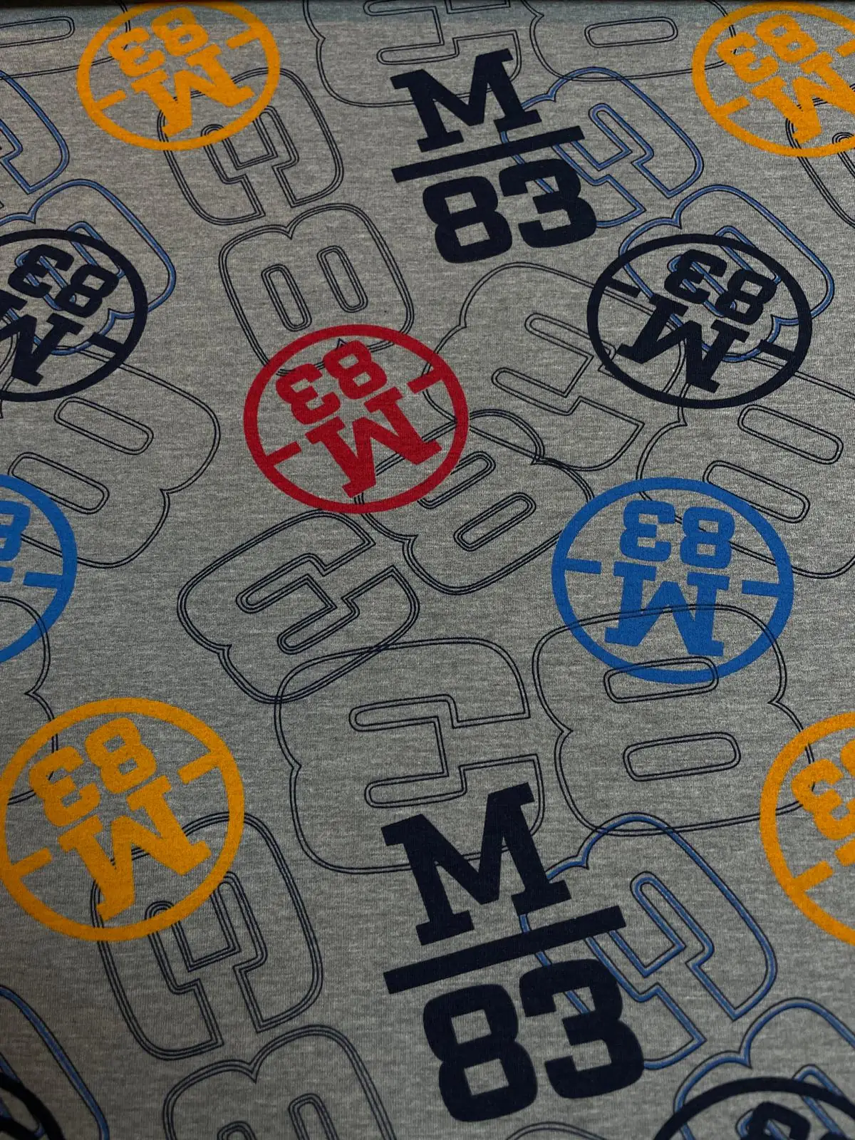 Sportlicher Baumwoll-Sweat (French Terry) in Grau-Meliert mit grafischem M83-Logo-Print in Dunkelblau, Rot, Gelb und Blau; ideal für coole Teens-Hoodies und Streetwear-Outfits.
