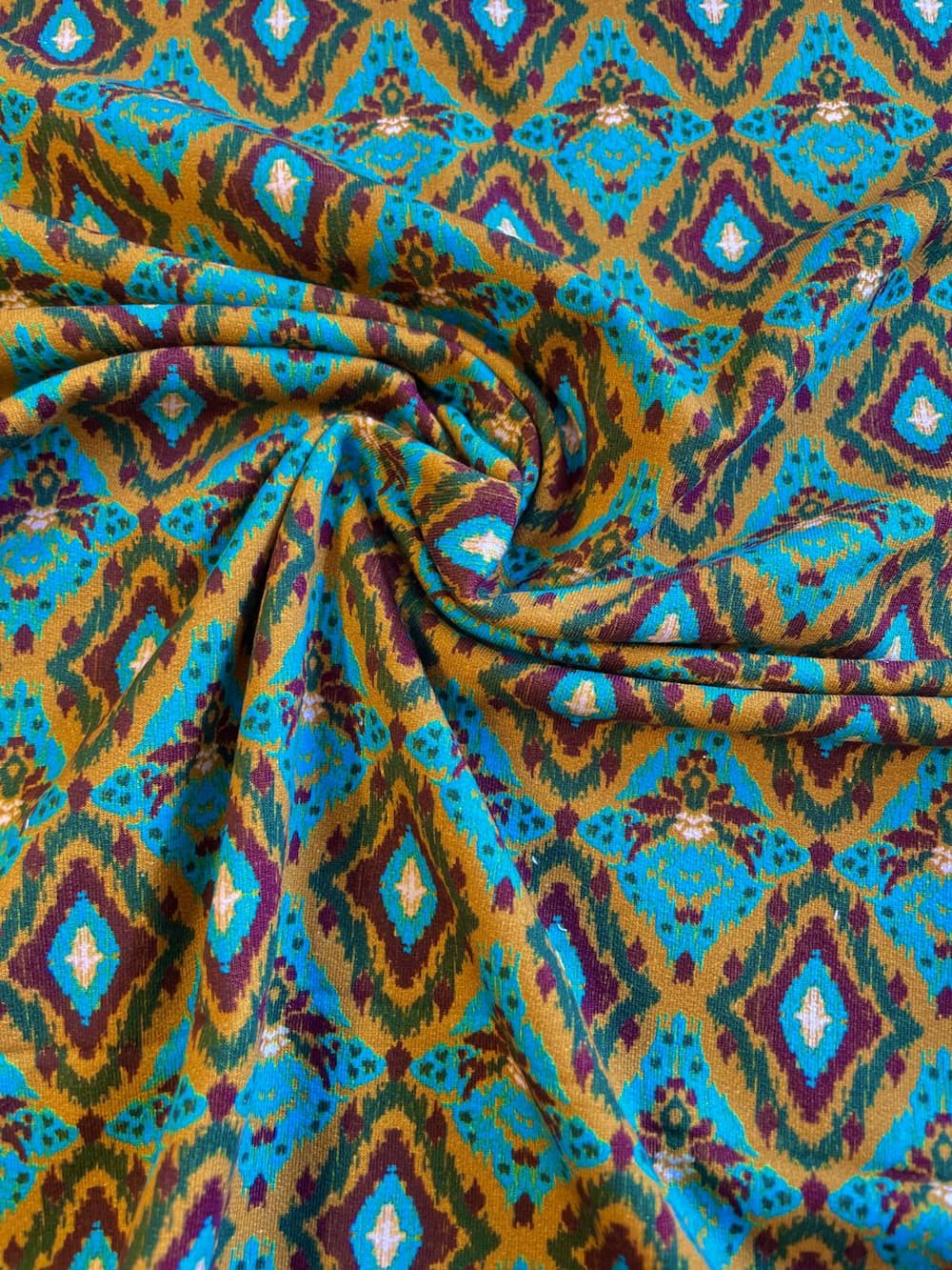 Drahtansicht des French Terry Sommersweats mit Ikat-Muster in Gold und Türkis als Meterware