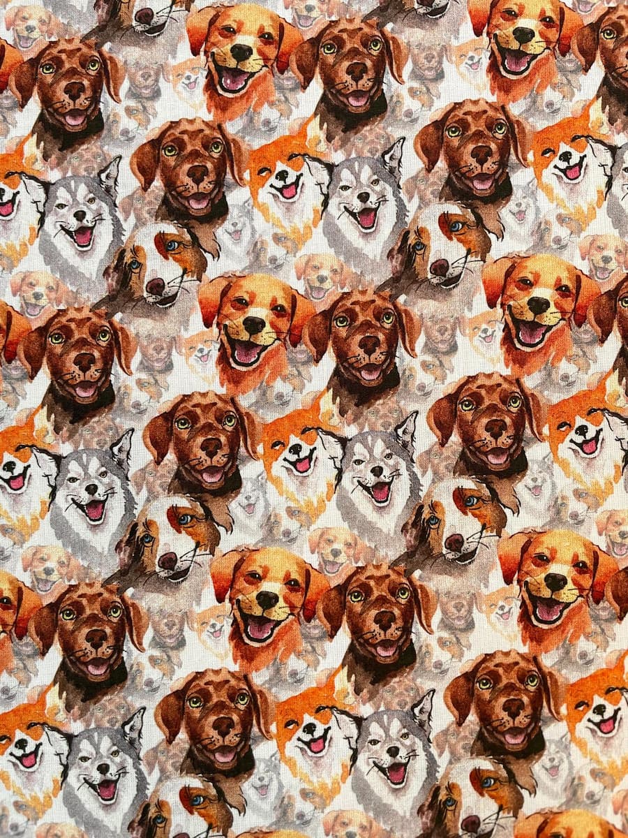 Hochwertiger Baumwoll-Webware Stoff mit flächendeckendem Muster aus verschiedenen illustrierten Hundeköpfen wie Golden Retriever und Husky in warmen Aquarellfarben.