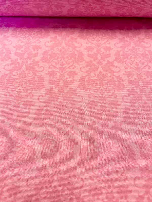 Nahaufnahme eines elastischen Bündchenstoffs mit barockem Ornament-Muster in verschiedenen Pink- und Rosatönen.