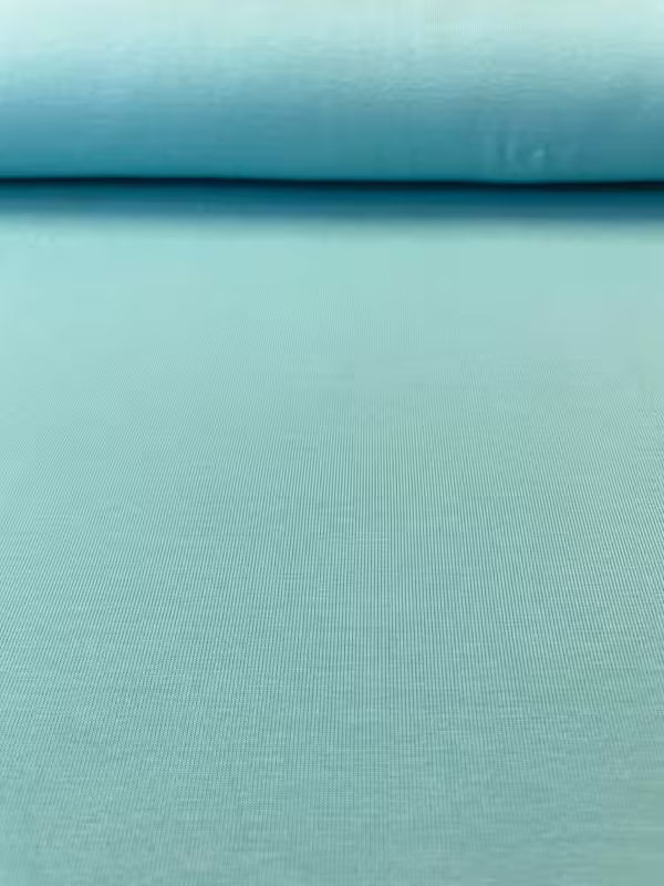 Nahaufnahme von weichem Baumwolljersey in zartem Mintgrün, glatte Oberfläche, 200g Gewicht, 150cm breite Meterware für Babykleidung.