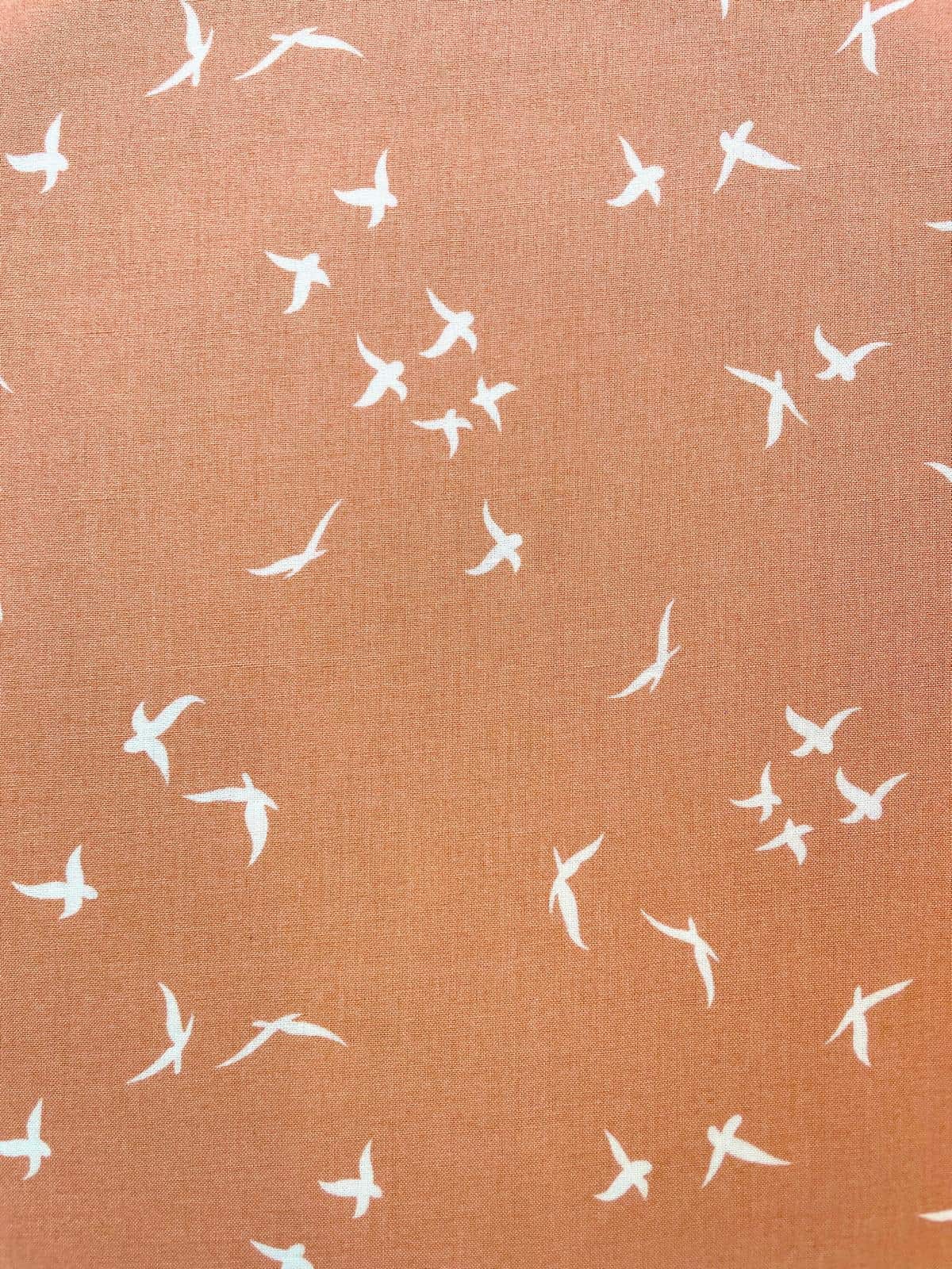Weich fließender Viskose-Webstoff in Terrakotta mit weißem Vogel-Print; Meterware für sommerliche Bekleidung.