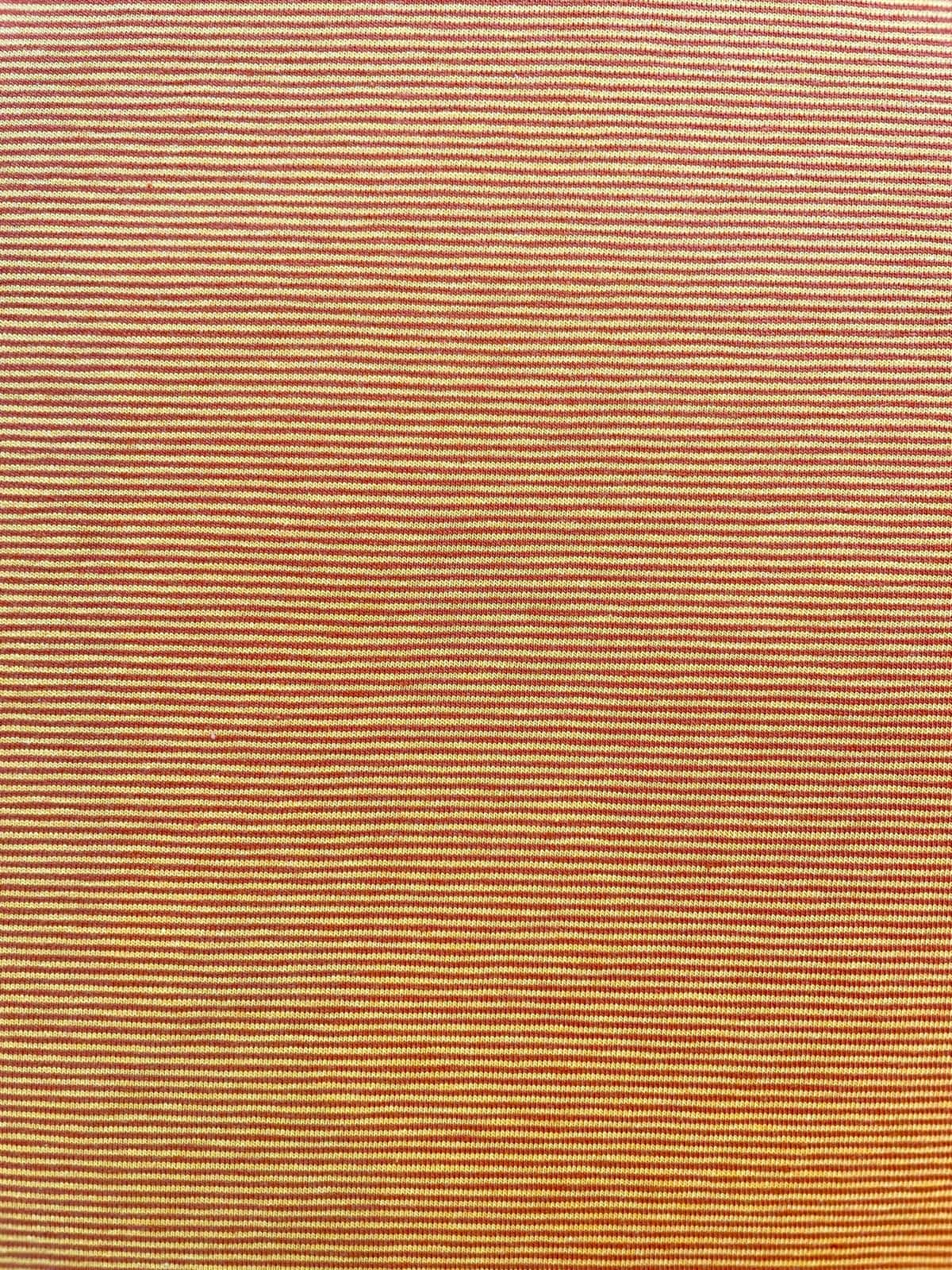 Detailansicht von Baumwolljersey Meterware mit feinen horizontalen Streifen in Terracotta und Creme; hochwertige Textur für elastische Kleidung und Heimtextilien.