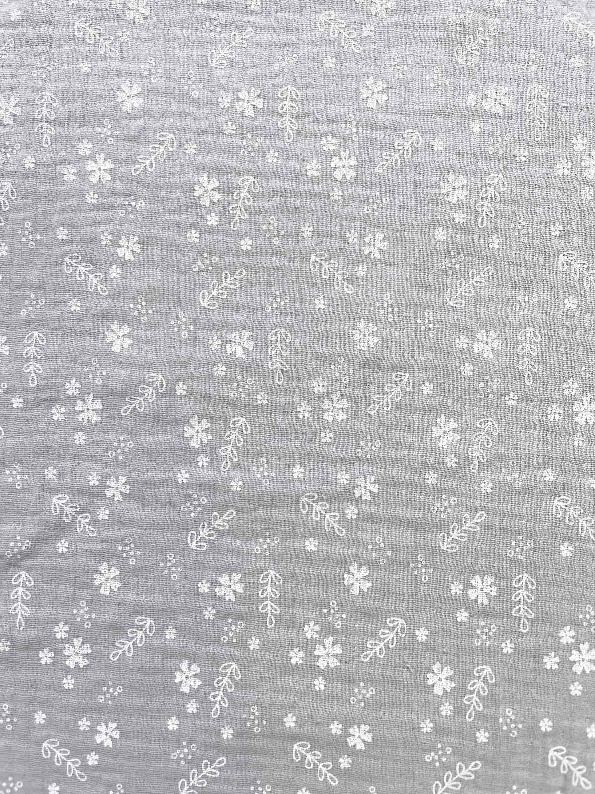 Hellgrauer Musselin-Stoff aus reiner Baumwolle mit feinen weißen Blüten und Zweigen, weiche Crinkle-Struktur für Bekleidung.