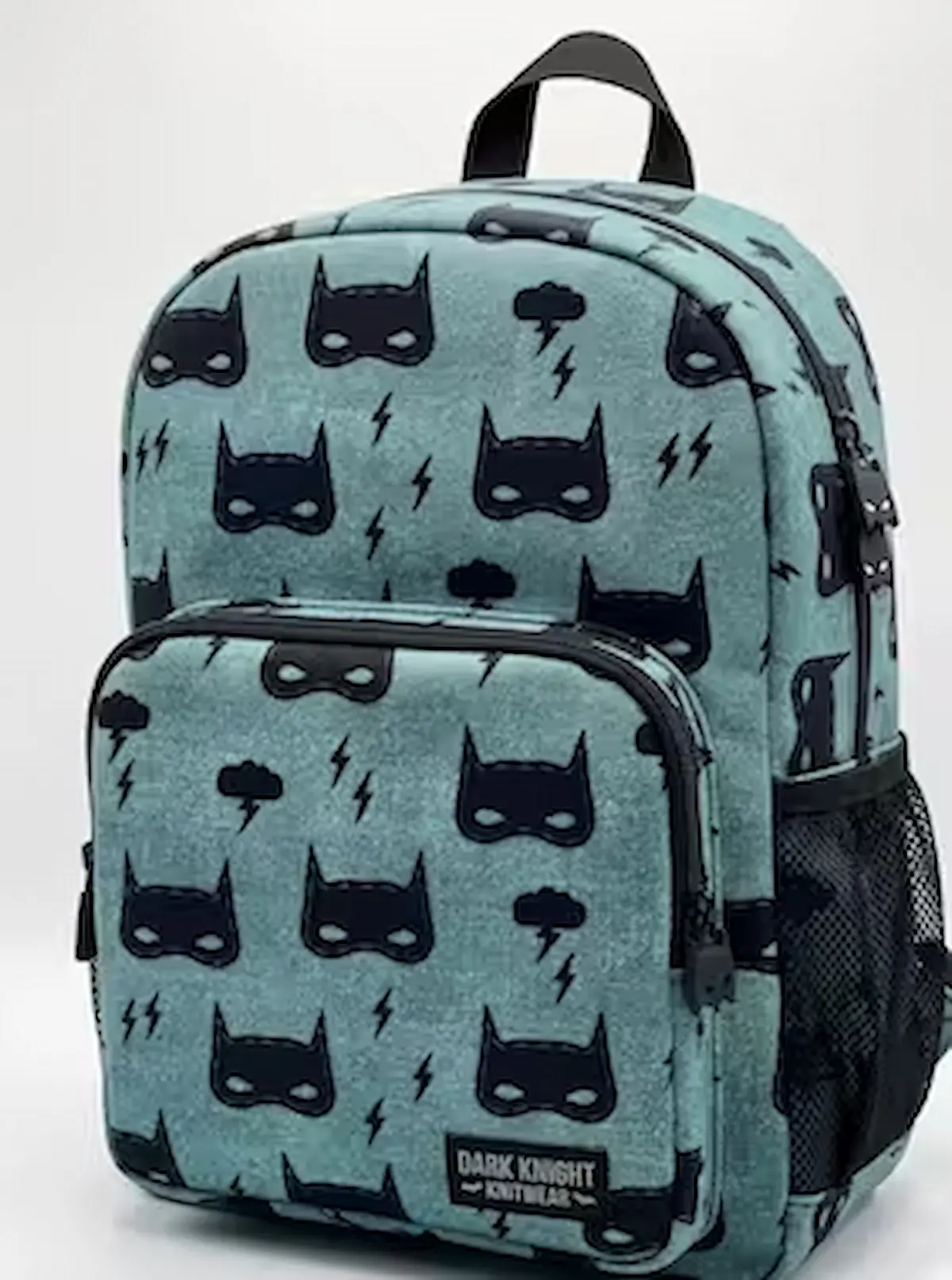 Robuster Baumwollstoff als Webware Meterware in Blaugrau mit schwarzen Superhelden-Masken und Blitzen, verarbeitet als fertiger Kinderrucksack vor weißem Hintergrund.