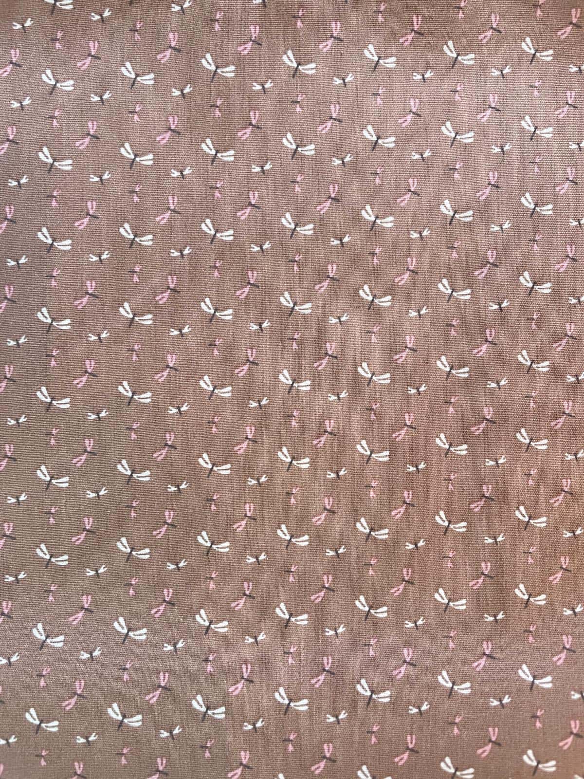 Feiner Baumwoll-Popeline Stoff in Beige-Braun mit kleinen Libellen-Motiven in Rosa und Weiß; Stoffgewicht 130g/m², Breite 147cm.