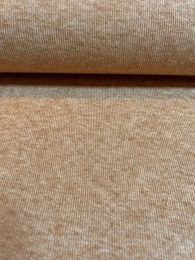 Ein weicher Feinstrickstoff mit dezenter vertikaler Rippenstruktur in einer warmen Zimt-Melange-Optik. Die Oberfläche zeigt ein harmonisches Spiel aus helleren und dunkleren Brauntönen. Ideal für gemütliche Cardigans, Pullover oder herbstliche Accessoires