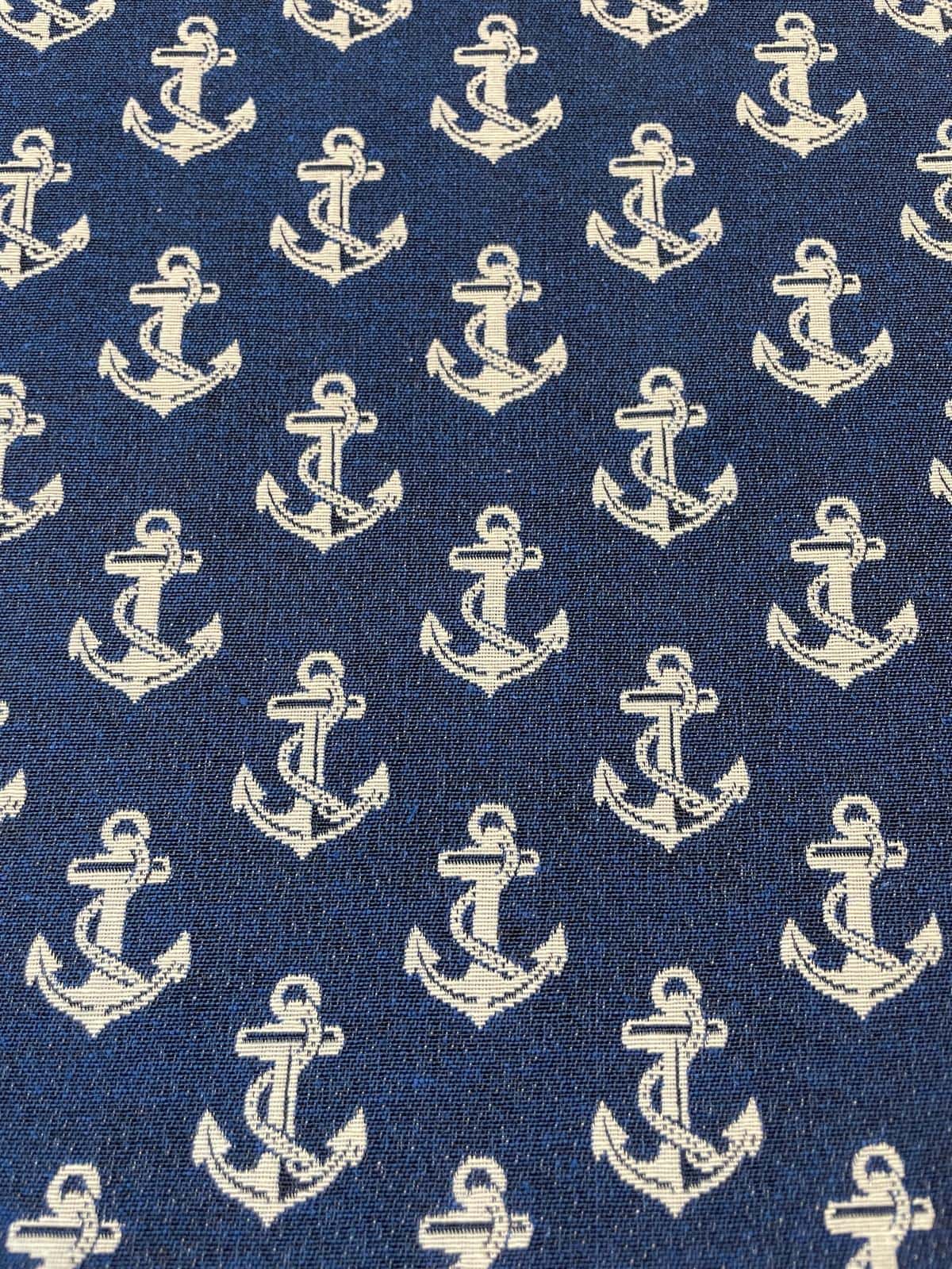 Gewebter Deko-Gobelinstoff als Meterware mit hellen, eingewebten Ankern auf einem kräftigen dunkelblauen Jacquard-Hintergrund.