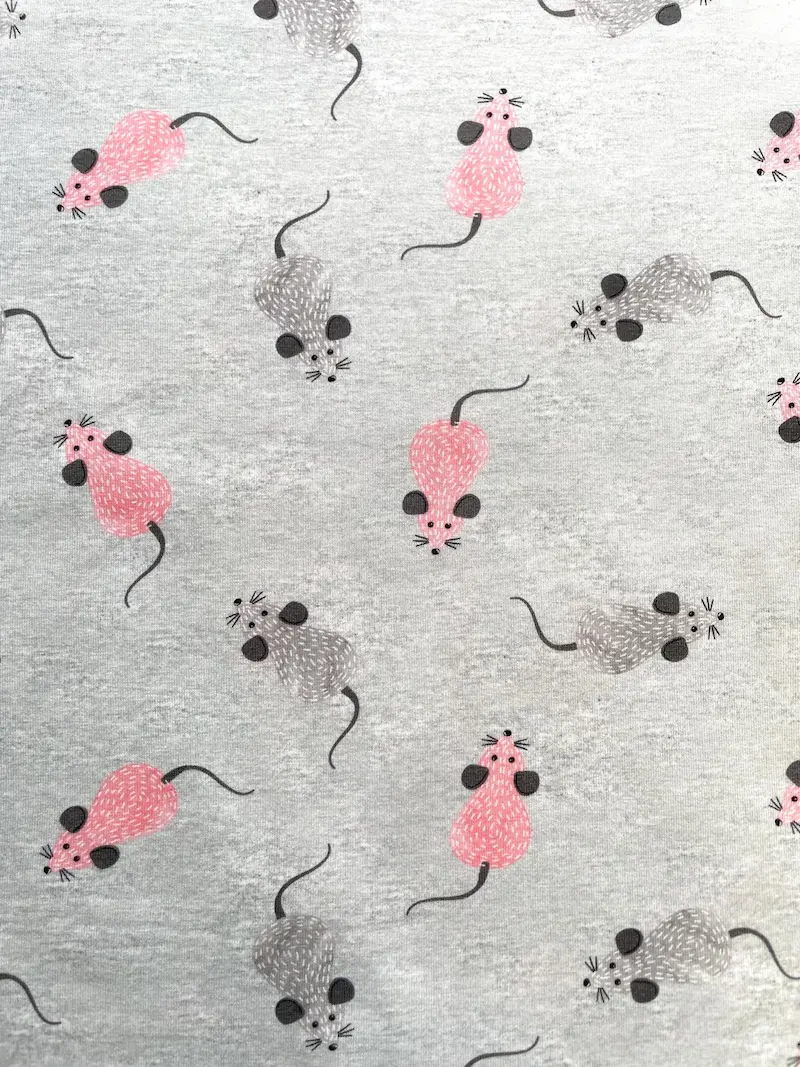 Hochwertiger melierter Baumwolljersey in Grau mit illustrierten rosa und grauen Mäusen, ideal als Meterware für Kinderbekleidung.